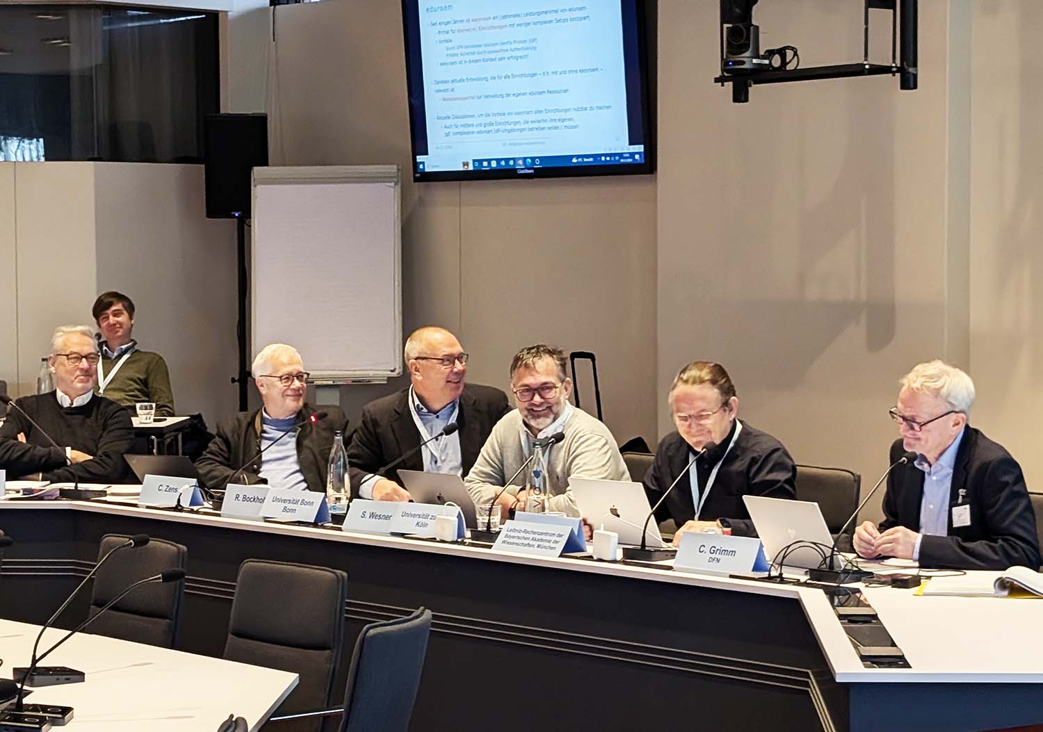 Auf dem Podium der 89. DFN-Mitgliederversammlung sind von links Jochem Pattloch, Christian Meyer, Christian Zens, Dr. Rainer Bockholt, Prof. Dr.-Ing. Stefan Wesner, Prof. Dr. Helmut Reiser und Dr. Christian Grimm zu sehen. Foto: Angela Lenz, DFN